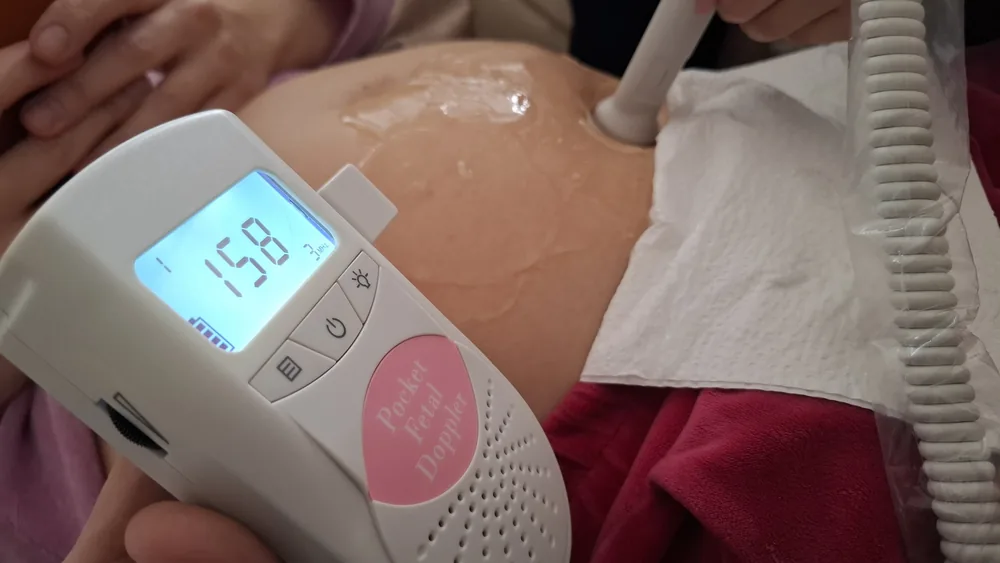 Domowe badanie tętna serca dziecka przenośnym dopplerem — Michał i Anna monitorujący ciążę w domu, 158 uderzeń na minutę