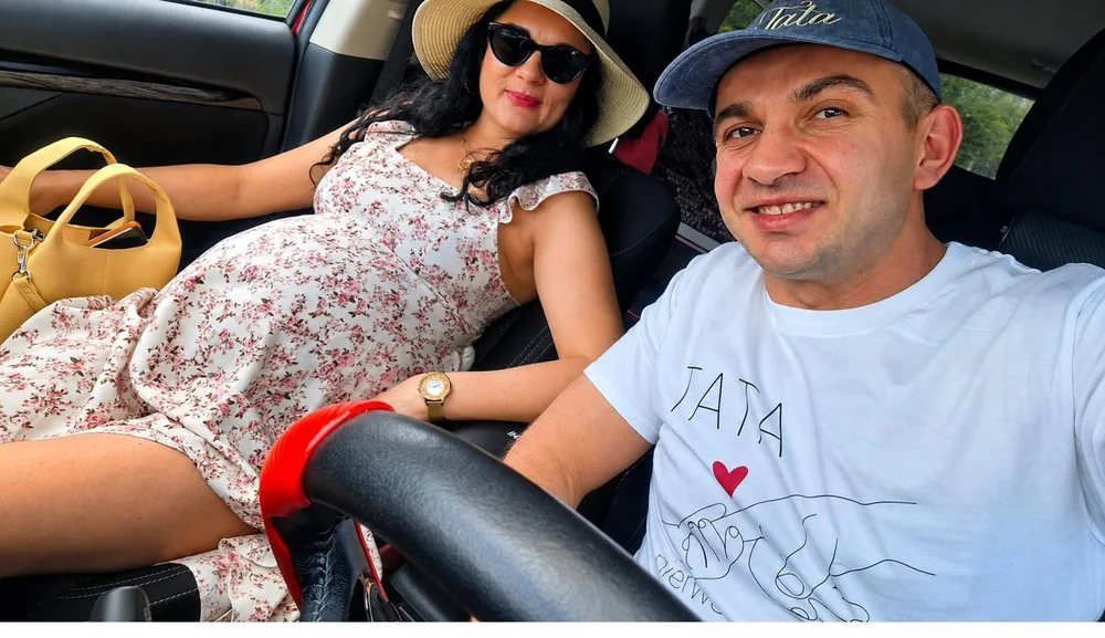 Michał w koszulce z napisem TATA za kierownicą, obok uśmiechnięta Anna w ciąży w kapeluszu — niedzielny wyjazd w drugim trymestrze