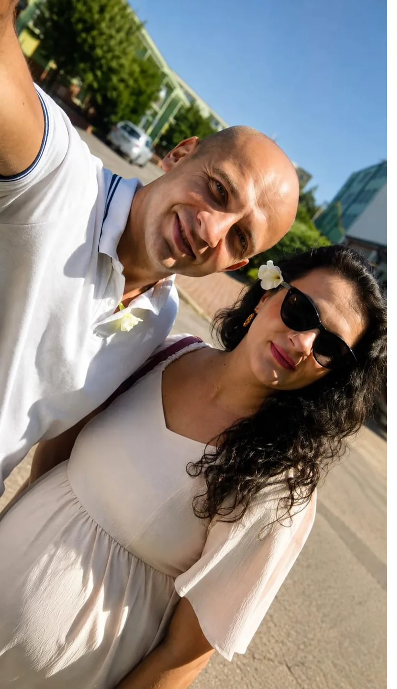 Uśmiechnięci Michał Czekaj i Anna na wakacyjnym selfie w słońcu na kilka tygodni przed porodem córki Wiktorii — twórcy PoródNaMiarę.pl